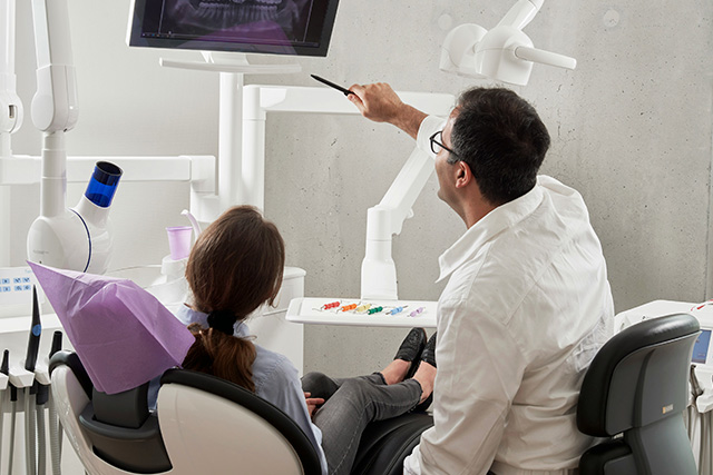 Dentiste qui montre une radio à un patient